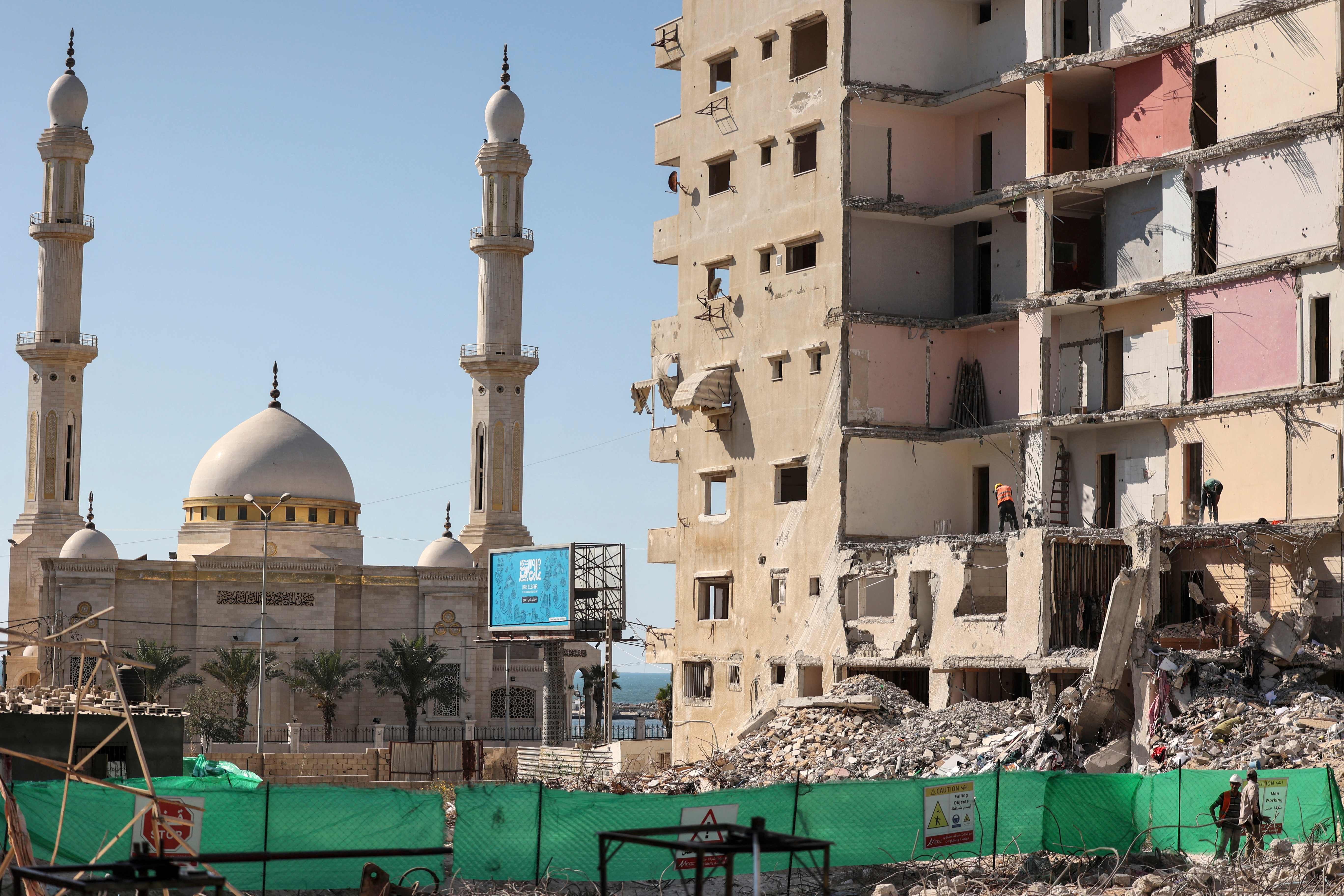 بدء إزالة بناية مدمرة في قطاع غزة بفعل العدوان الإسرائيلي العام الماضي .. تصوير: "الفرنسية"