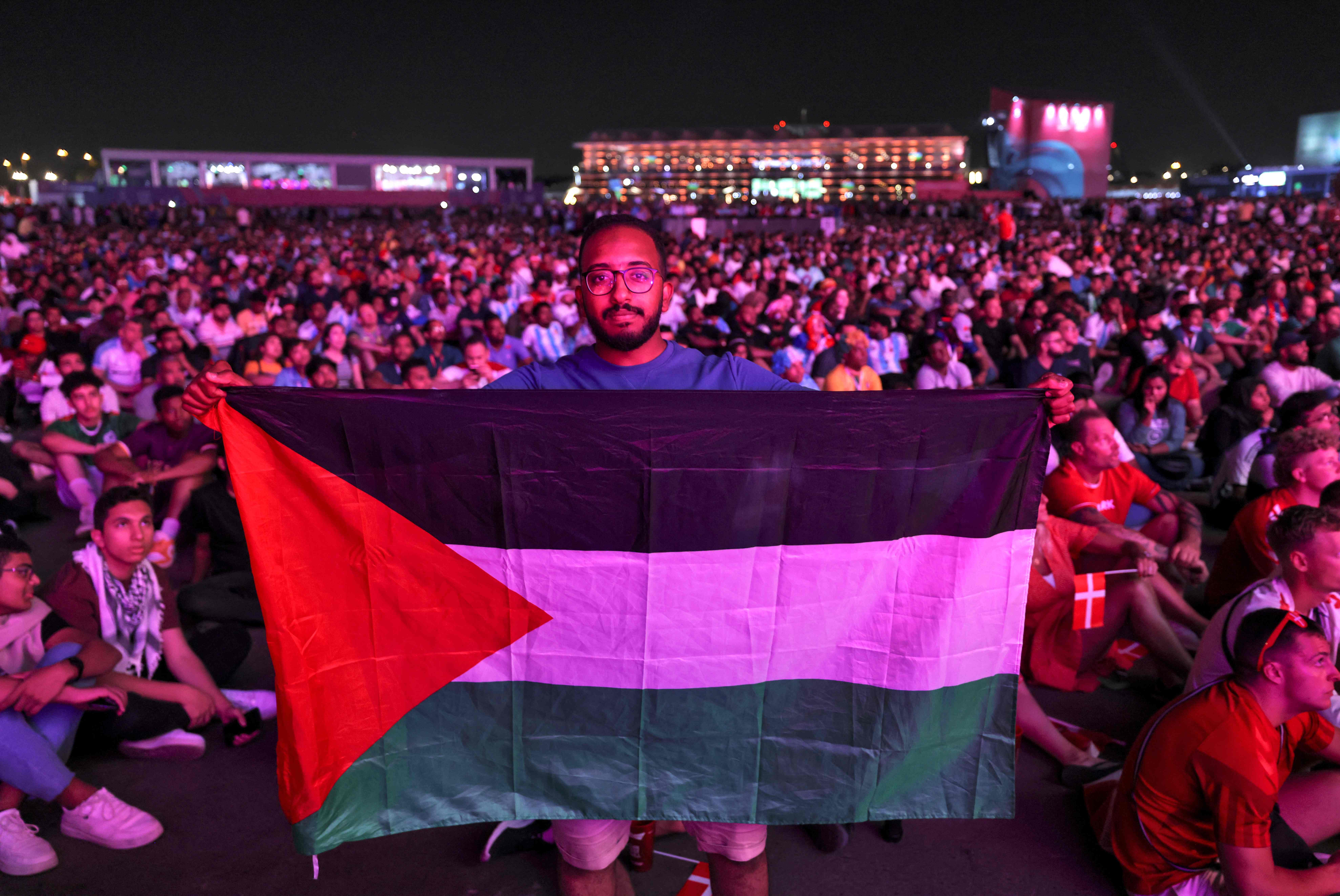 رفع العلم الفلسطيني خلال حضور مباريات كأس العالم في مناطق مفتوحة بالدوحة .. تصوير: "الفرنسية