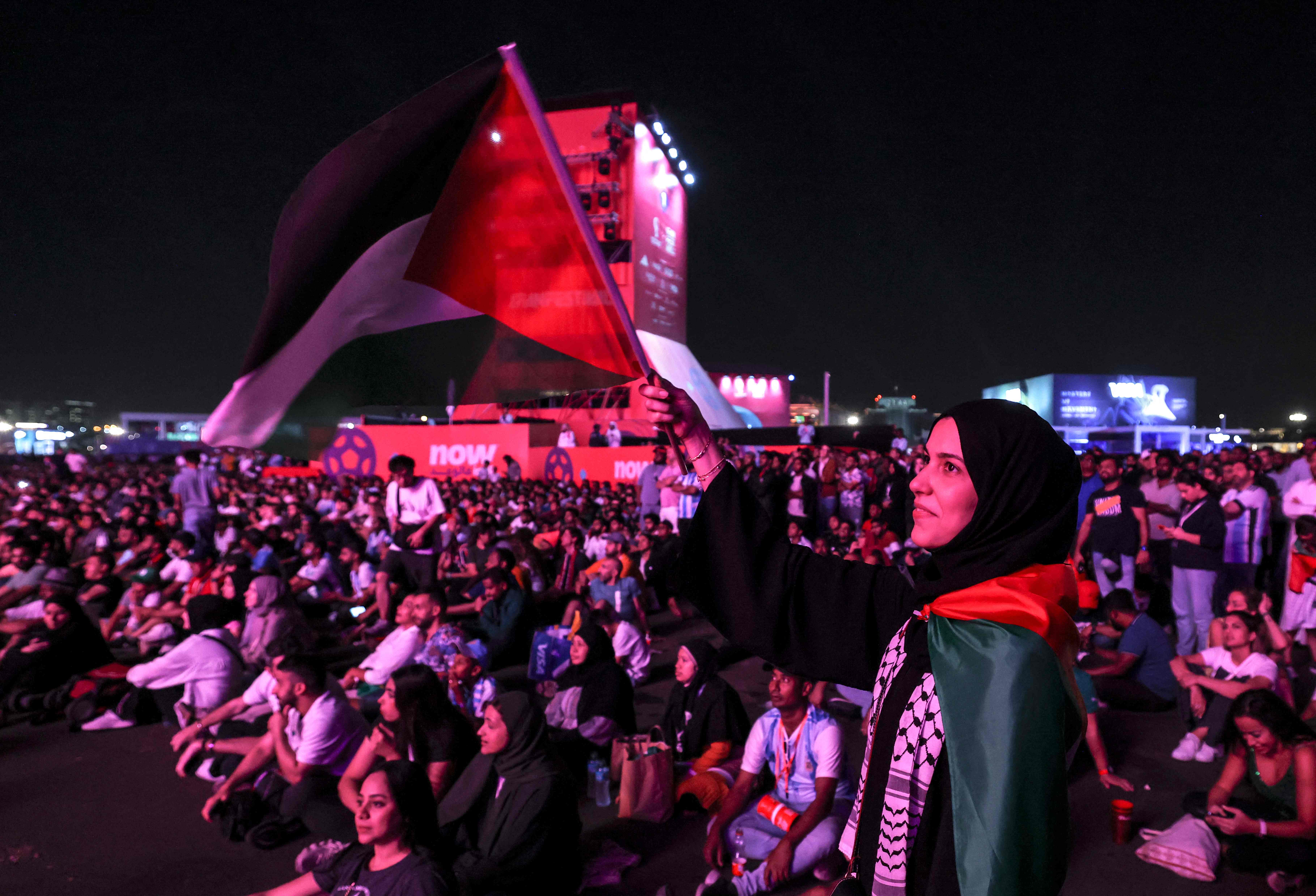 رفع العلم الفلسطيني خلال حضور مباريات كأس العالم في مناطق مفتوحة بالدوحة .. تصوير: "الفرنسية