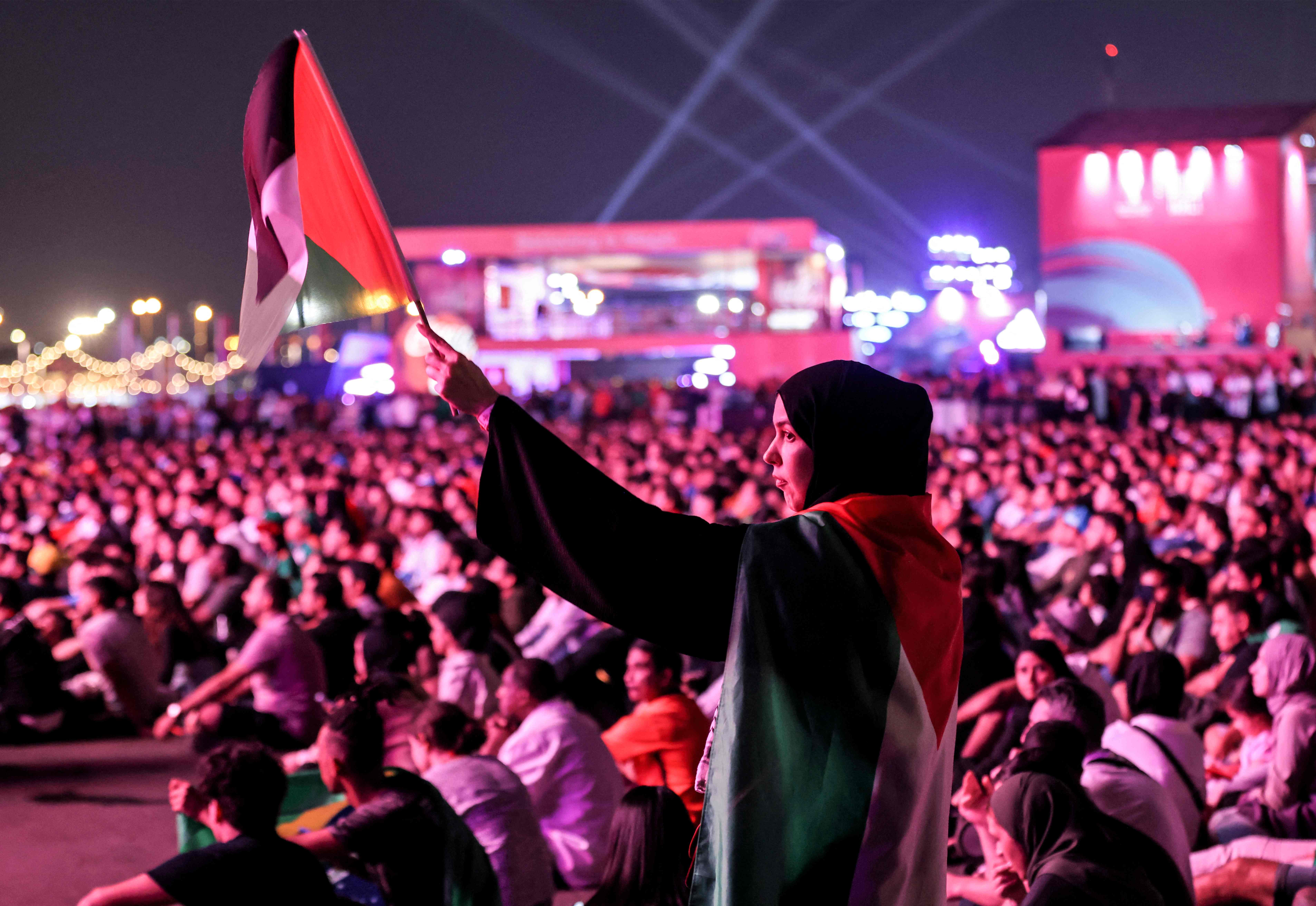 رفع العلم الفلسطيني خلال حضور مباريات كأس العالم في مناطق مفتوحة بالدوحة .. تصوير: "الفرنسية