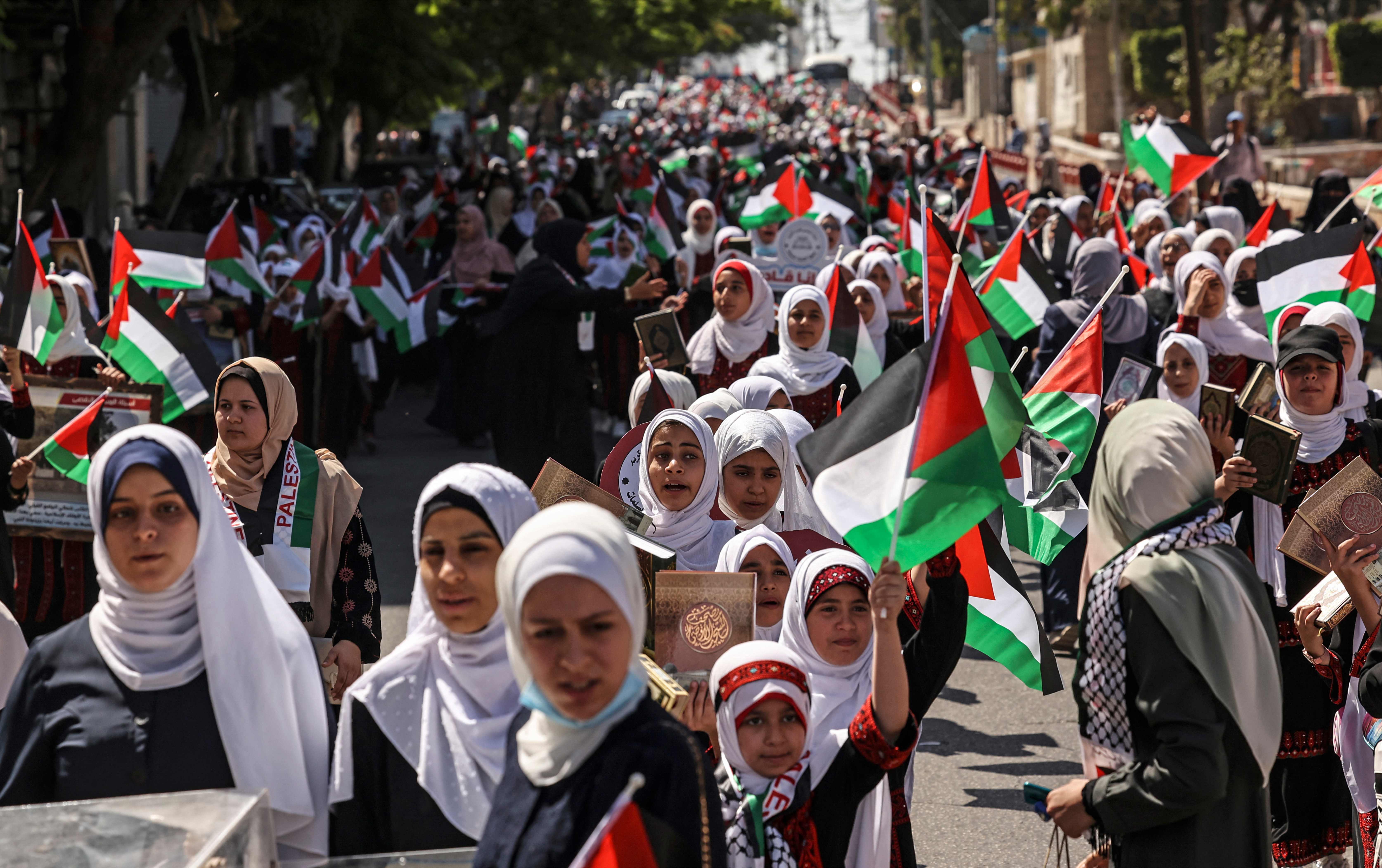 مسيرة أعلام لفتيات مخيم صيفي بغزة .. تصوير: "الفرنسية"