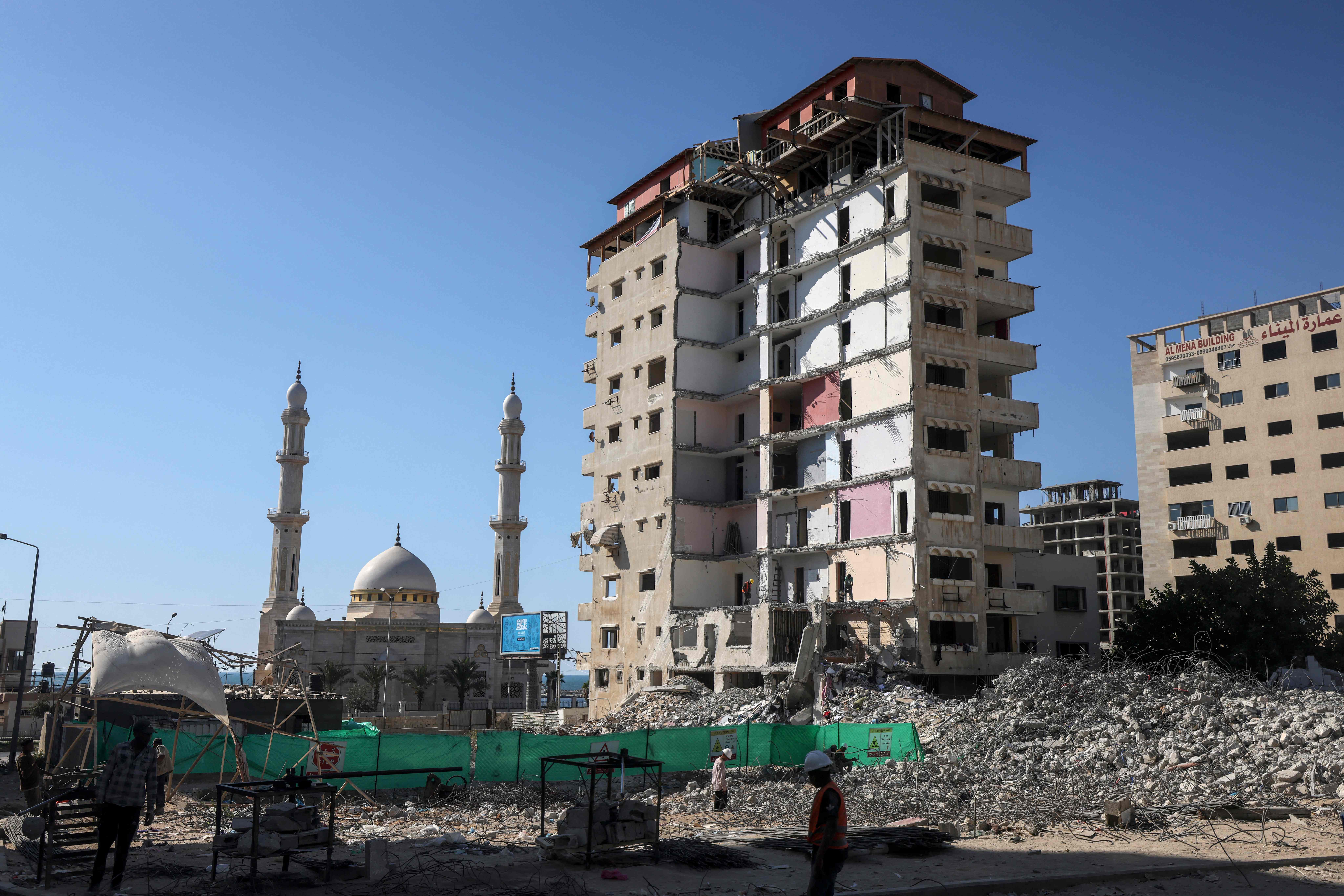 بدء إزالة بناية مدمرة في قطاع غزة بفعل العدوان الإسرائيلي العام الماضي .. تصوير: "الفرنسية"