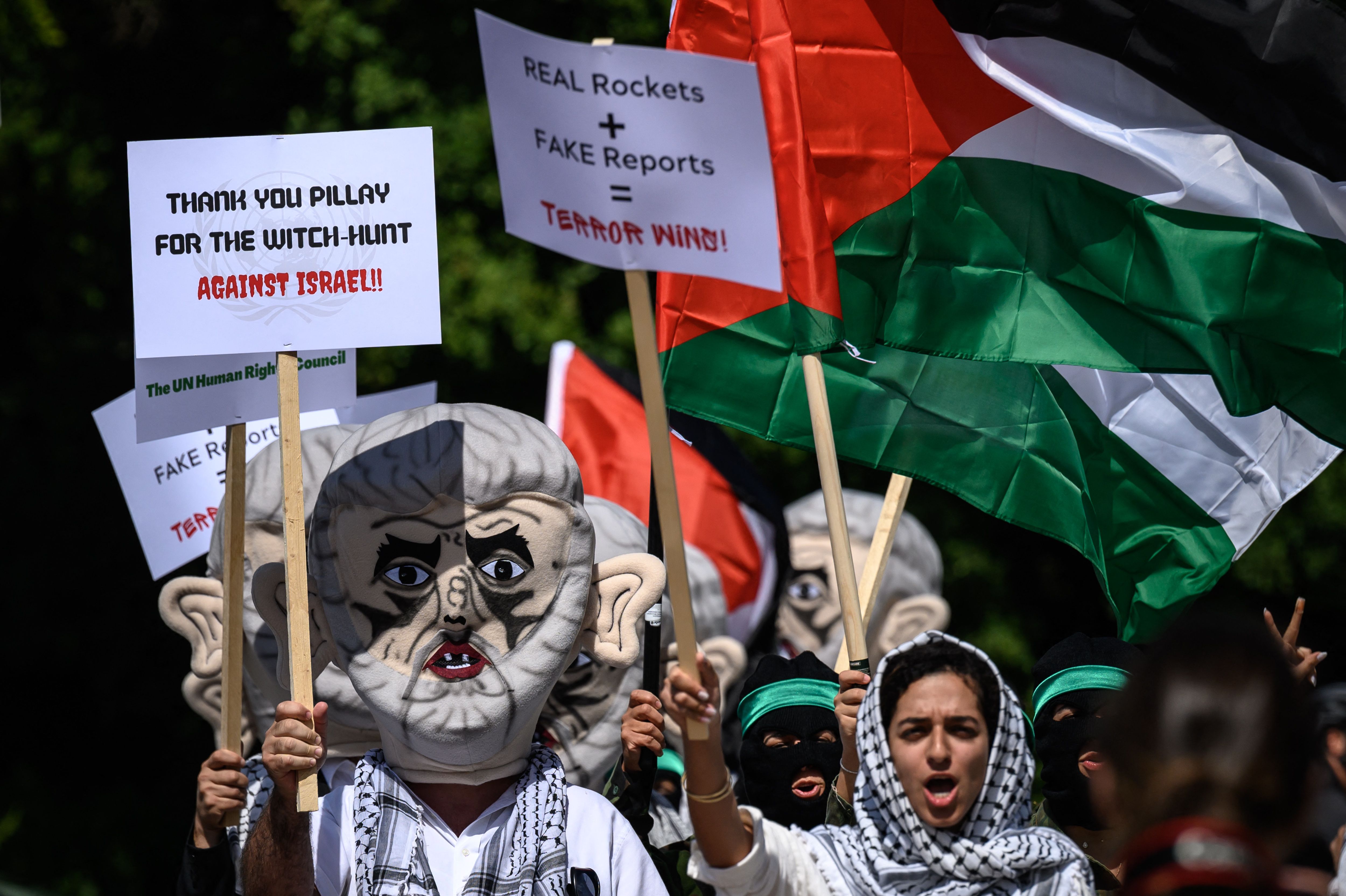 جنود إسرائيليون يضعون قناعًا ليحيى السنوار ويرفعون العلم الفلسطيني أمام مقر الأمم المتحدة في جنيف احتجاجًا على تقرير يصنف إسرائيل بأنها "دولة فصل عنصري".. تصوير: "الفرنسية"