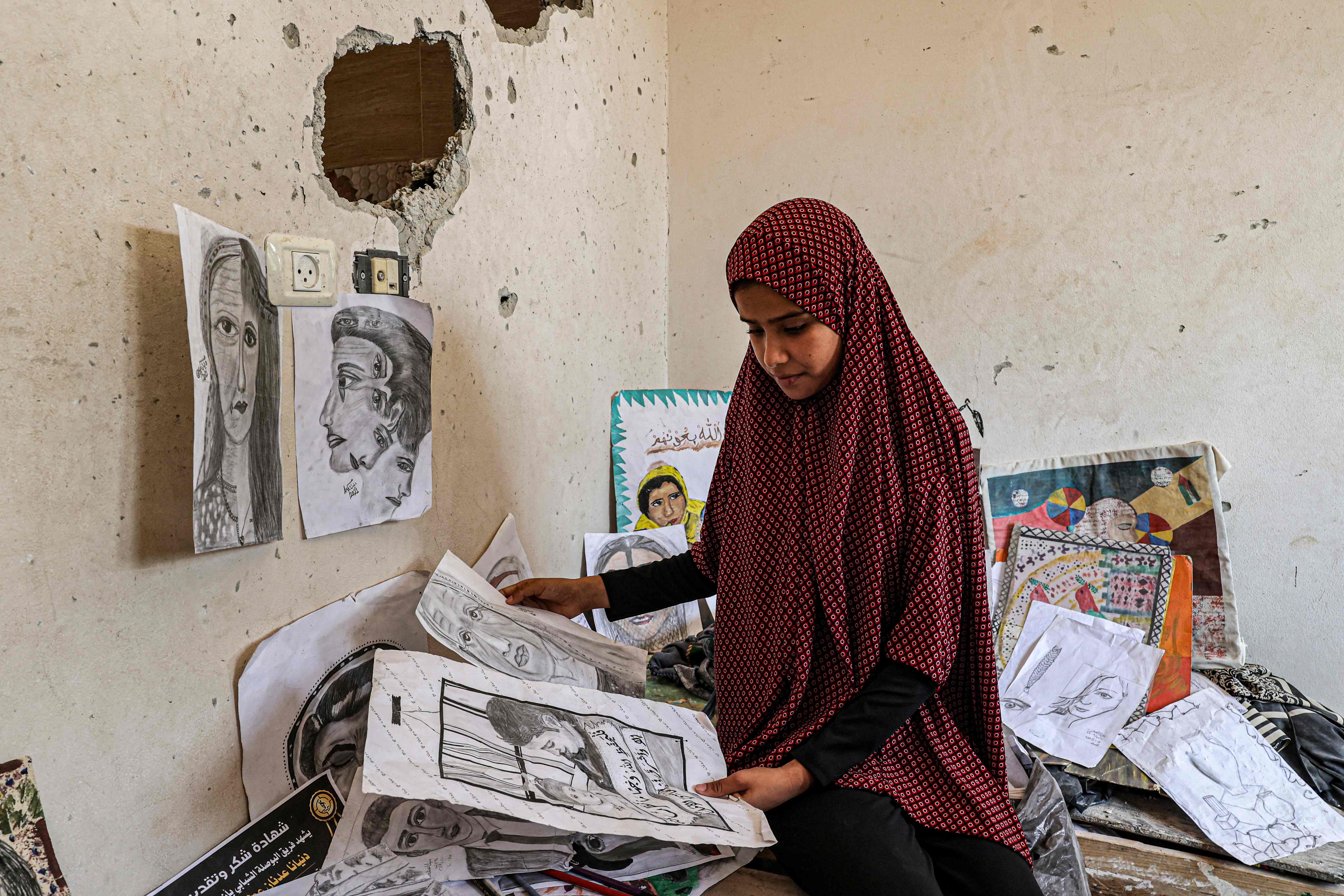 ما تبقى من رسومات  الشابة دنيانا العمور التي استشهدت في العدوان الأخير على غزة.. تصوير: "الفرنسية"