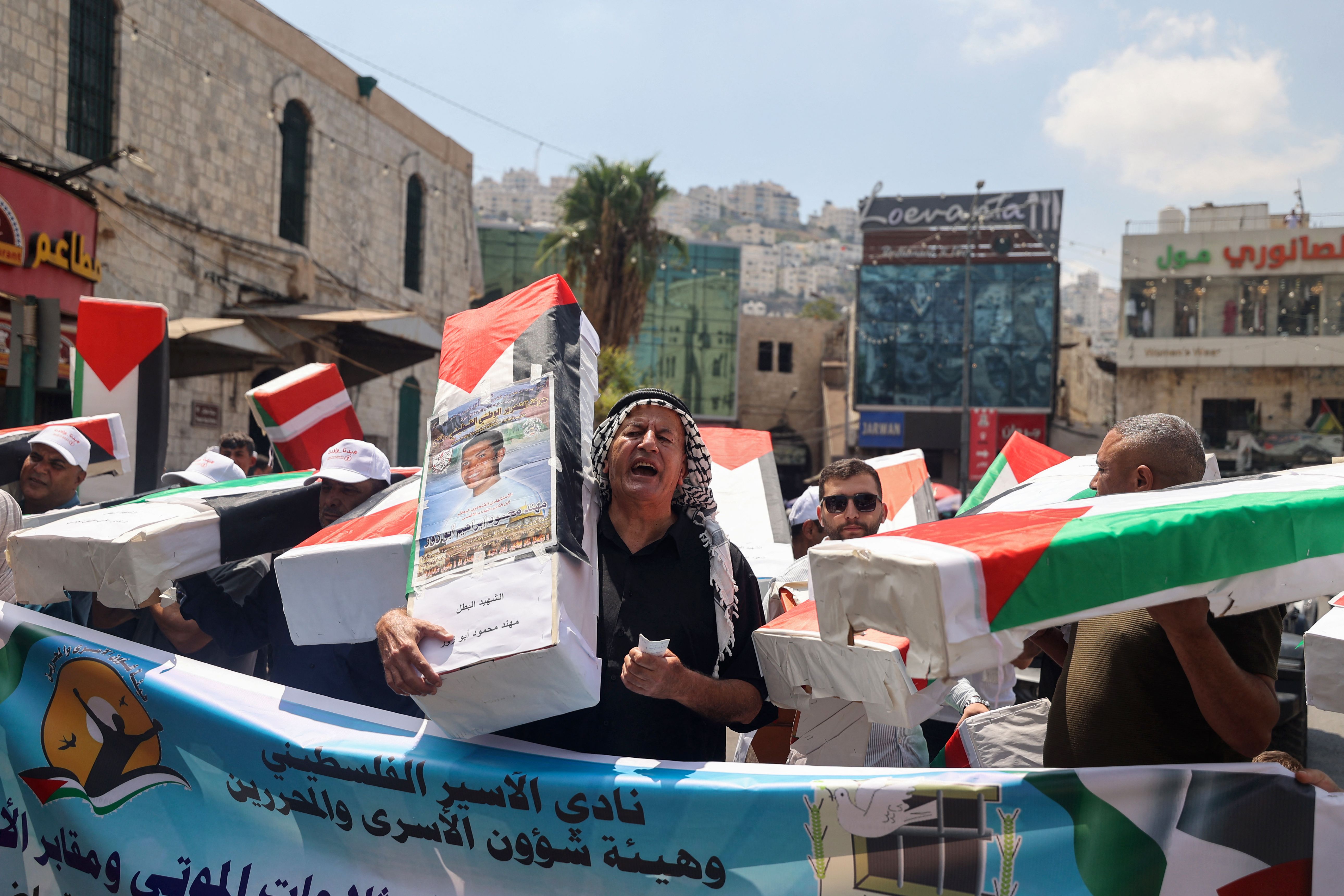 فلسطينيون يشاركون في حملة للمطالبة باسترداد جثامين الشهداء المحتجزة من قبل الاحتلال .. تصوير: "الفرنسية"