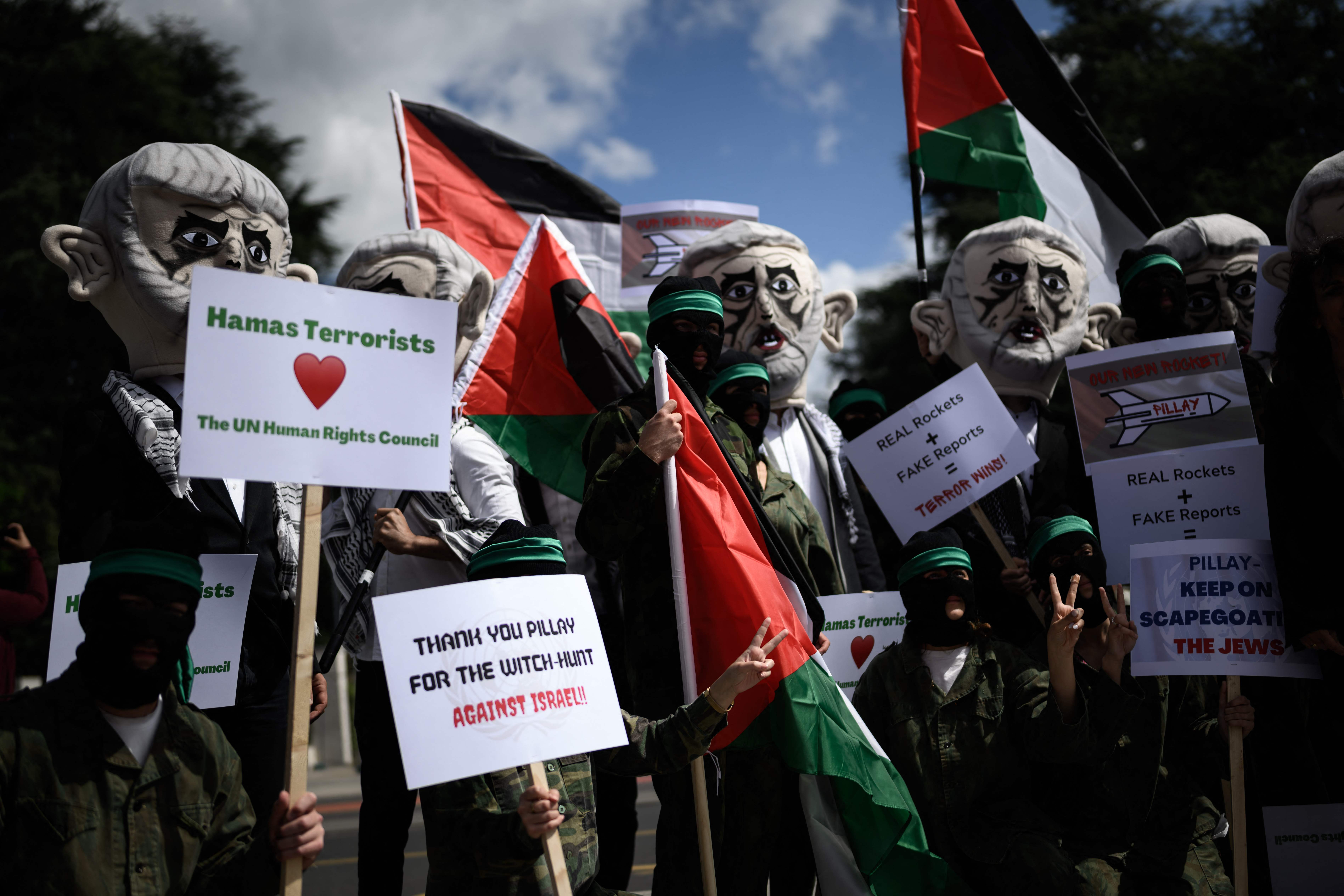 جنود إسرائيليون يضعون قناعًا ليحيى السنوار ويرفعون العلم الفلسطيني أمام مقر الأمم المتحدة في جنيف احتجاجًا على تقرير يصنف إسرائيل بأنها "دولة فصل عنصري".. تصوير: "الفرنسية"